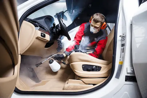 Detailer nanáší keramickou ochranu na kapotu vozu v pražském studiu